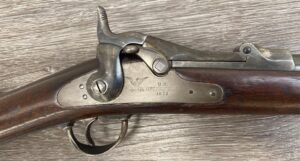 Vintage Springfield 1873SRC lever action rifle in .45-70 with a clear cartouche, showing signs of historical use and age.