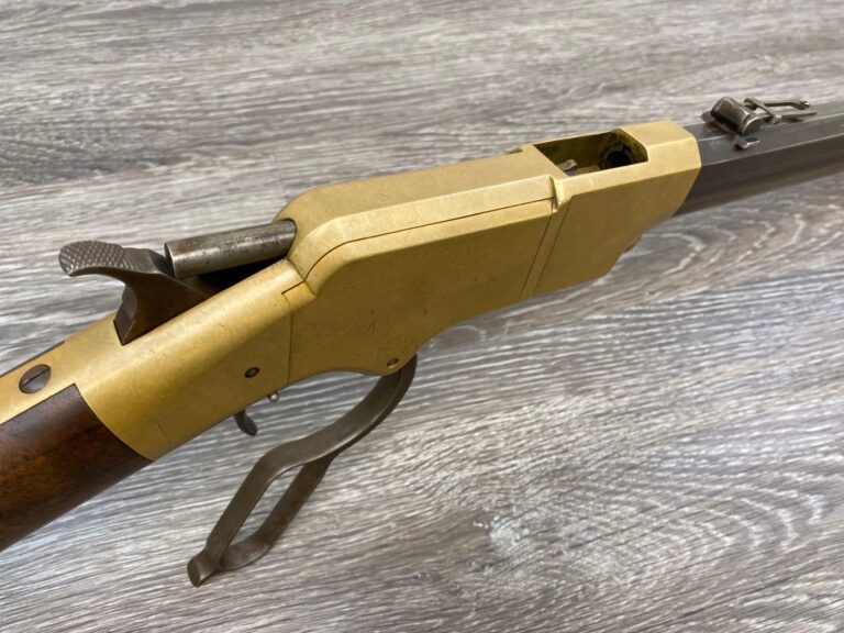 Vintage 1860 Henry lever action rifle in .44 Rimfire, with an octagon barrel, brass receiver, and walnut stock.