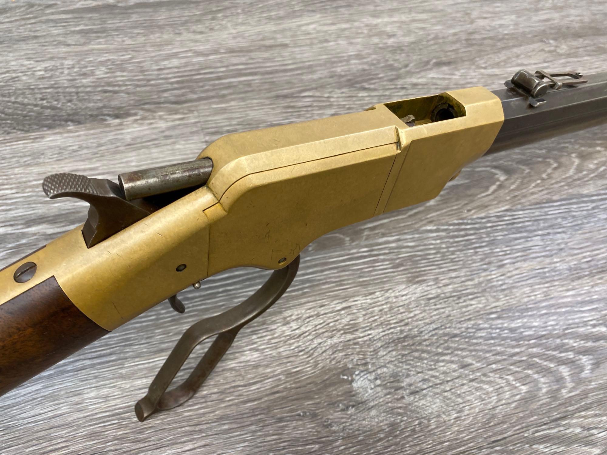 Vintage 1860 Henry lever action rifle in .44 Rimfire, with an octagon barrel, brass receiver, and walnut stock.