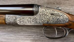 Holland & Holland Royal Deluxe Paradox 12 gauge side-by-side shotgun with fine scroll engraving, gold inlays, and an oil-finished hardwood stock.