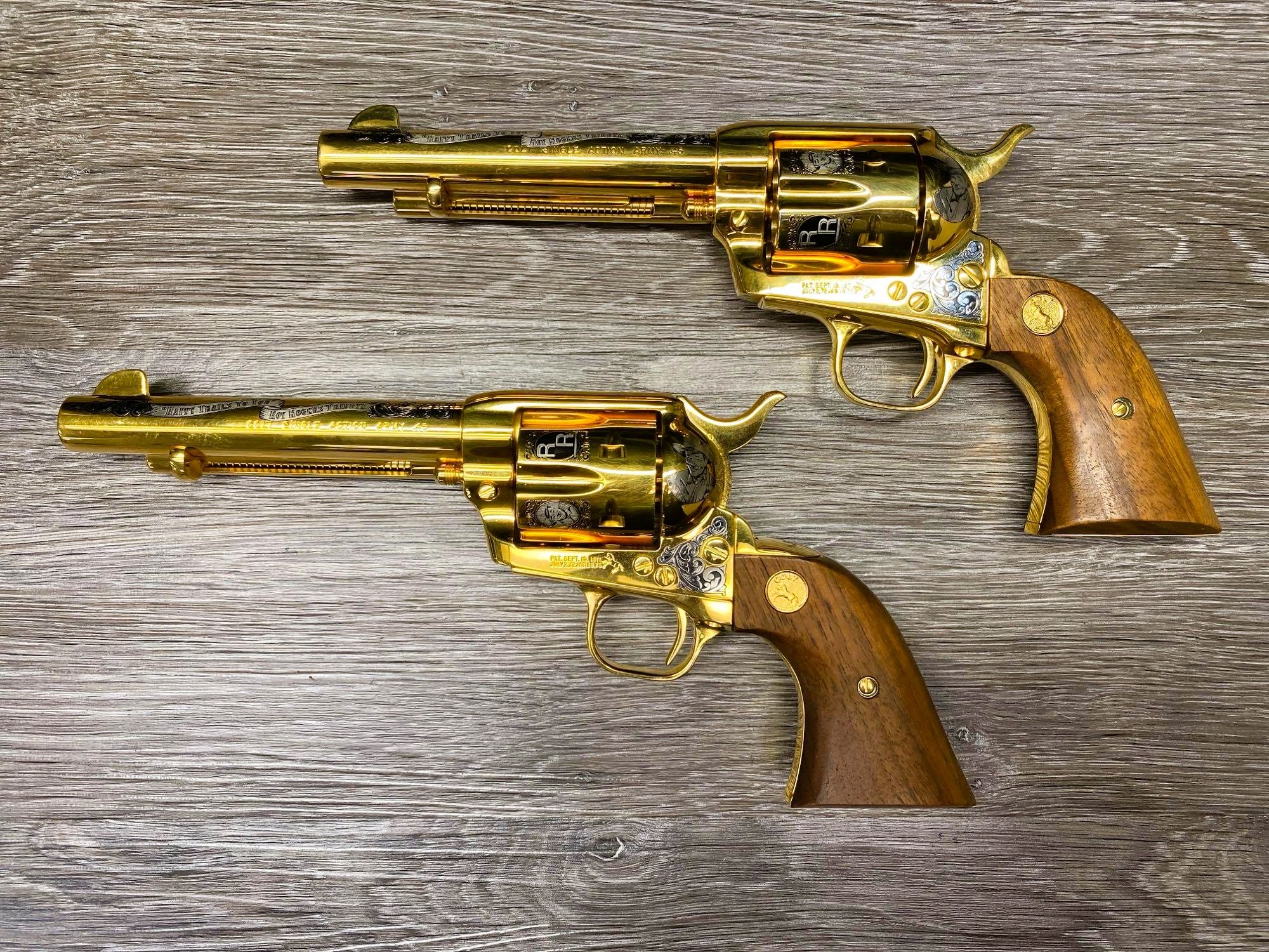 Pair of highly decorated, gold-finished Colt Single Action Army revolvers from the "America Remembers" series, with a custom double holster rig.