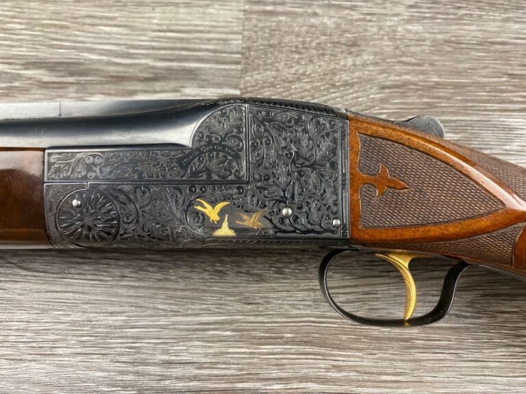 Rare Ithaca Single Shot Model 7E 12 gauge shotgun, a two-barrel set with gold inlays and intricate vine engraving, in a canvas hardcase.