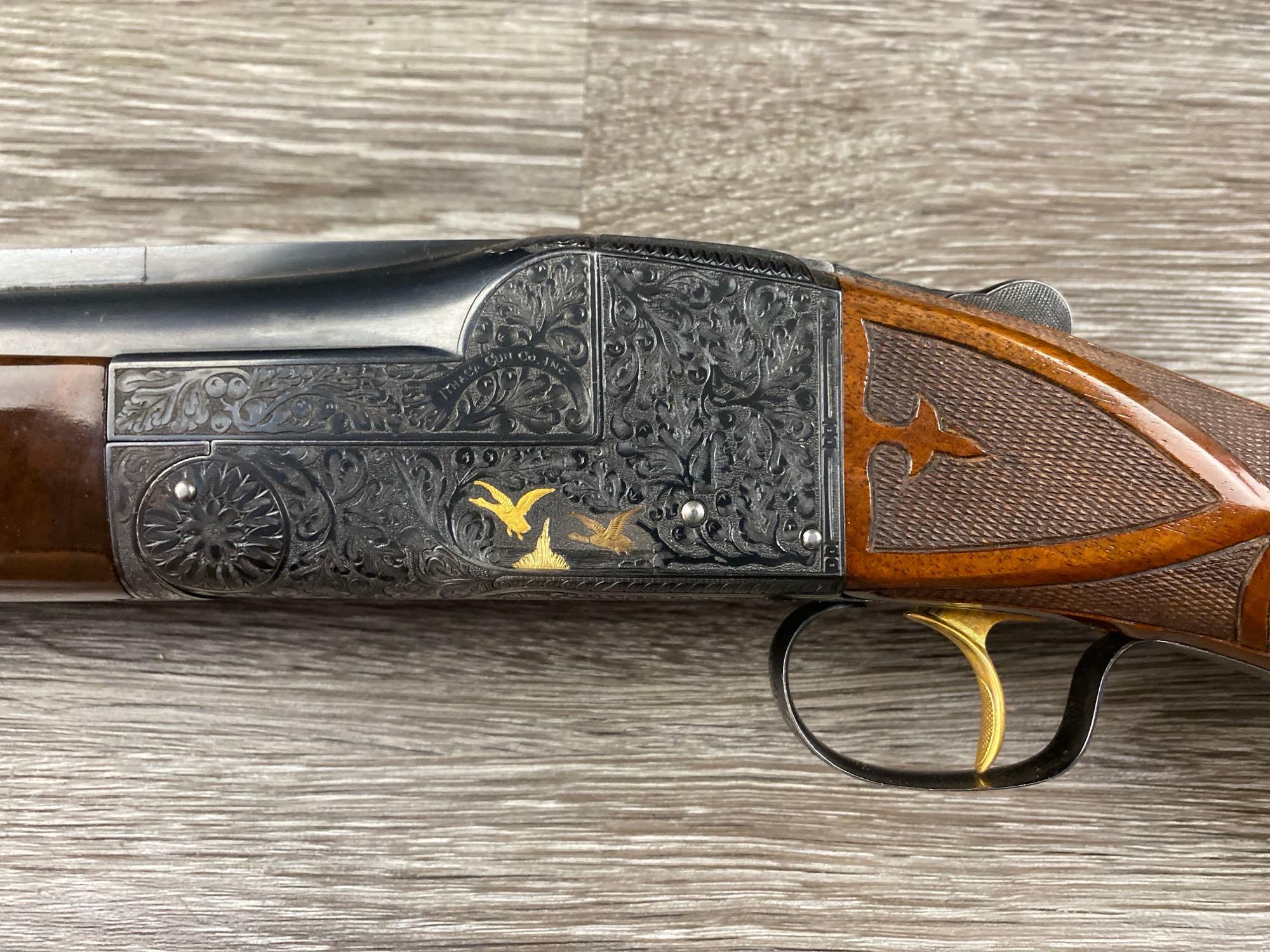 Rare Ithaca Single Shot Model 7E 12 gauge shotgun, a two-barrel set with gold inlays and intricate vine engraving, in a canvas hardcase.
